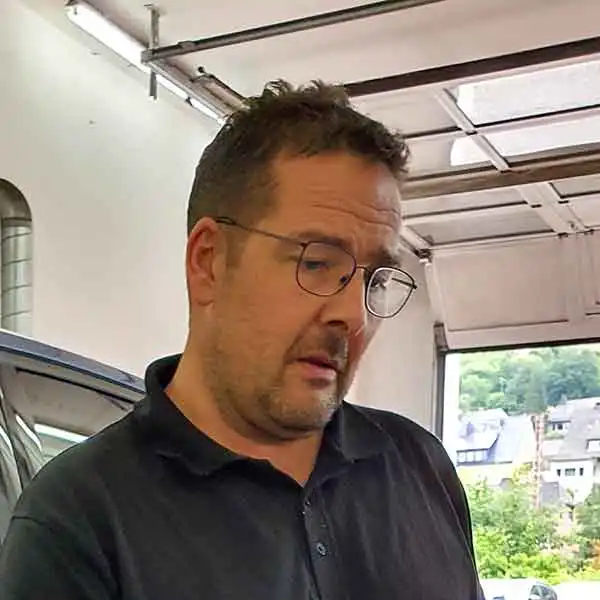 Portraitfoto von Kfz-Meister Rouven Picker in seiner Werkstatt in Altenhundem Rouven Picker - Autohaus Picker Lennestadt